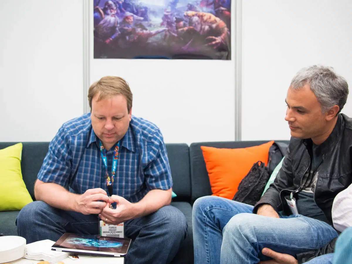 Feargus Urquhart a Sergey Orlovsky sedí na pohovce na veletrhu E3 2013.