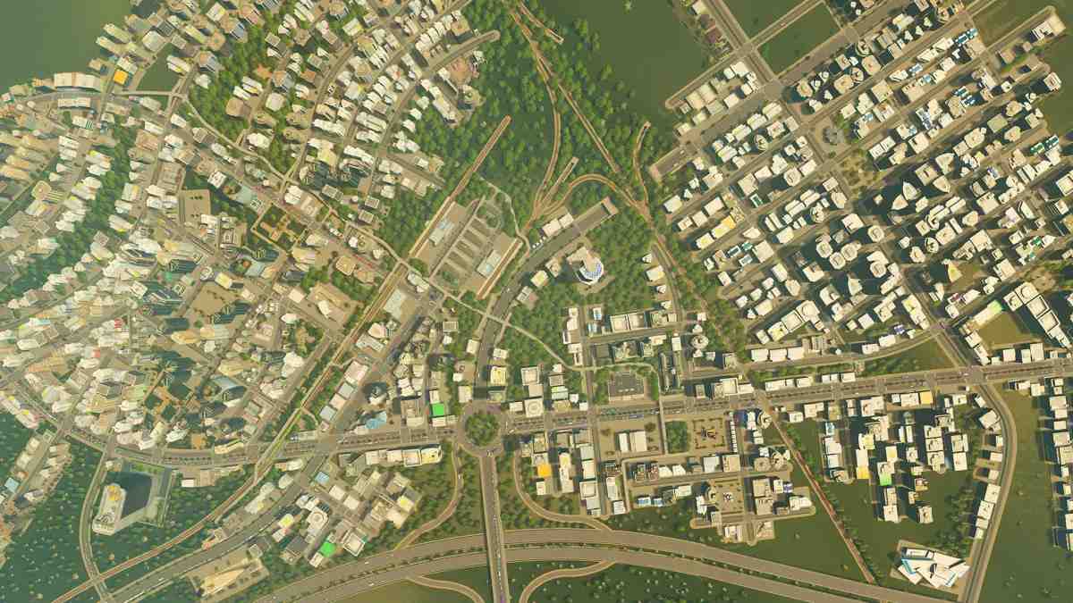 Pohled z nadhledu na hustou městskou zástavbu se silnicemi, obytnými a komerčními budovami v Cities: Skylines